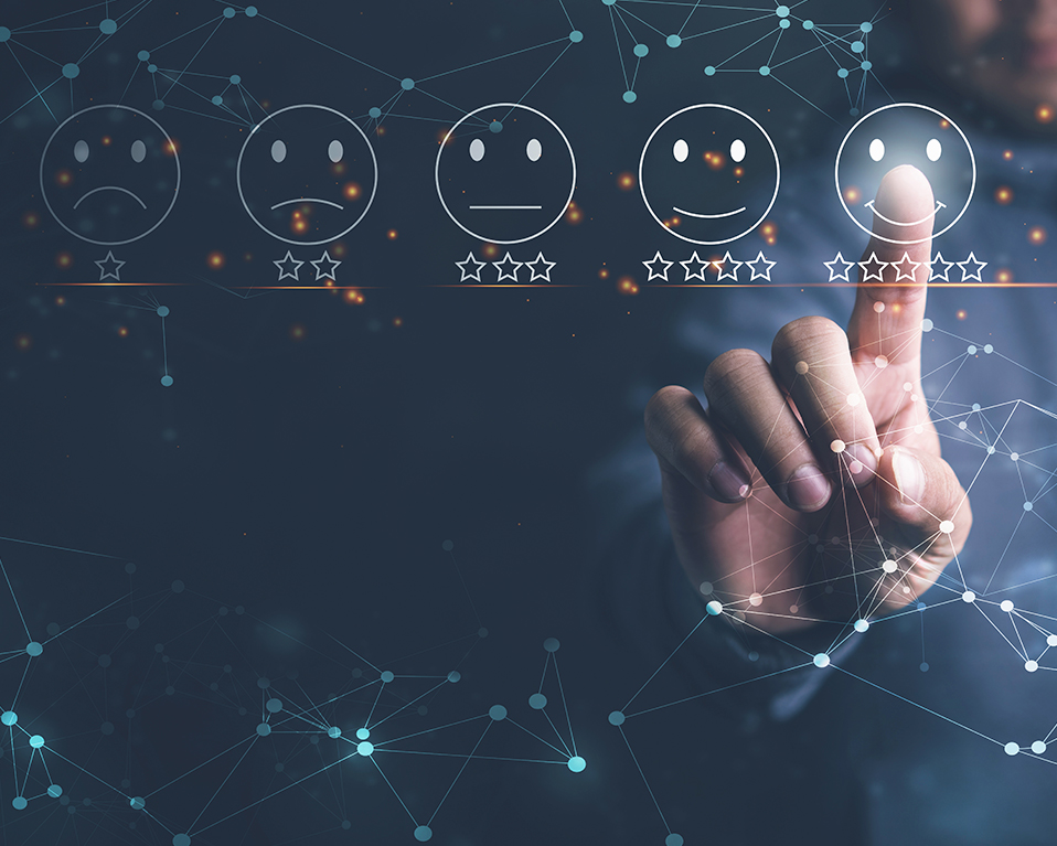 Composición en la que aparecen varios símbolos para evaluar la satisfacción de un servicio sobre una pantalla táctil virtual, de fondo se puede observar a una persona tocando con el dedo uno de estos símbolos.