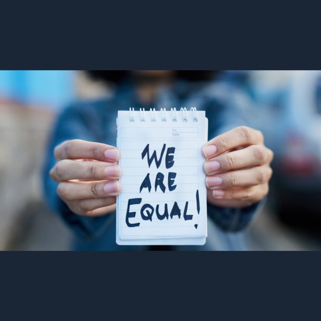 Aparece una imagen en la que una mujer sostiene una libreta en la que pone "We are equal!"