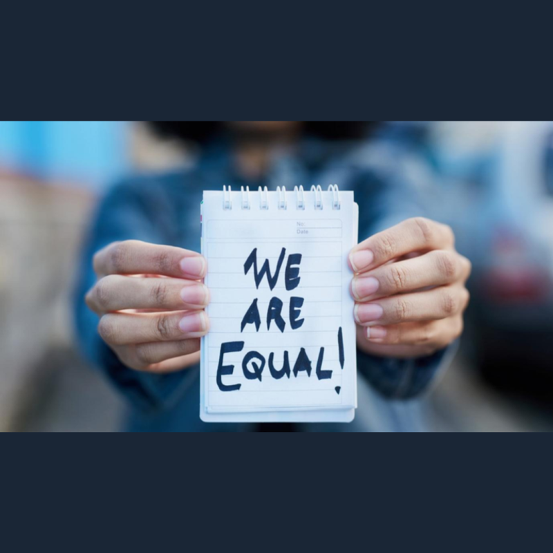 Aparece una imagen en la que una mujer sostiene una libreta en la que pone "We are equal!"